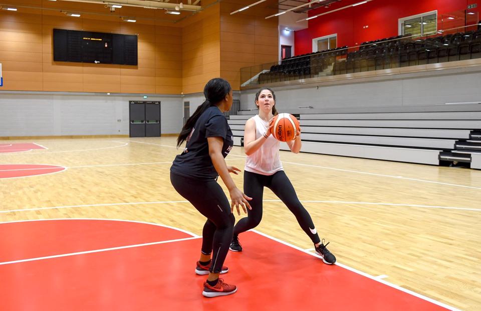 Two people playing basket ball in the high performance sports hall
